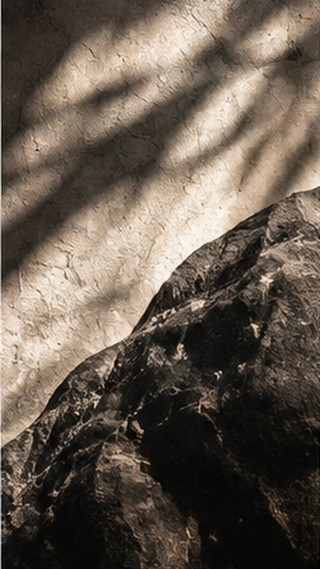 Dark veined stone and sunlit textured plaster